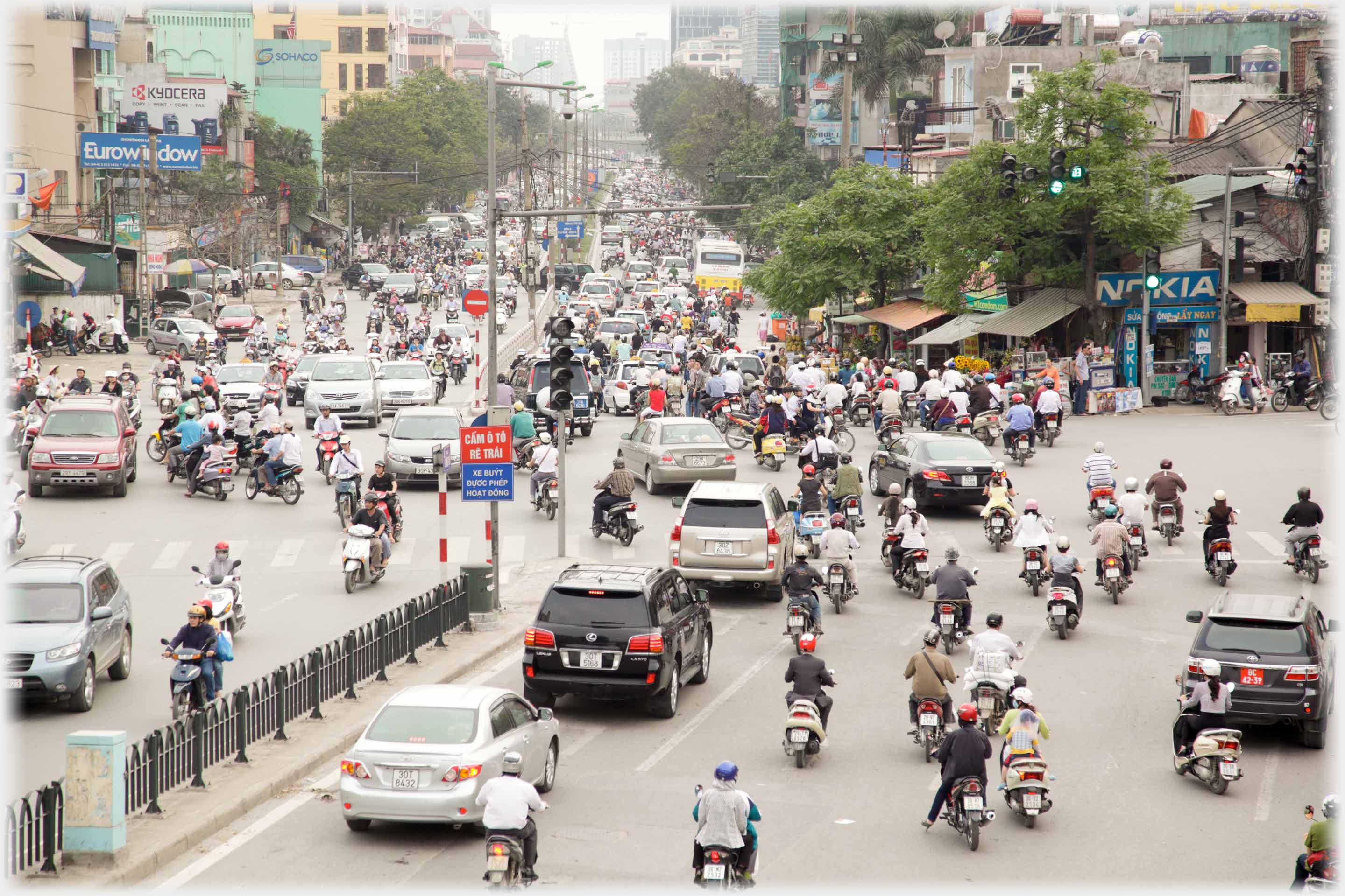 Looking down on busy city intersection with heavy traffic away into the distance.