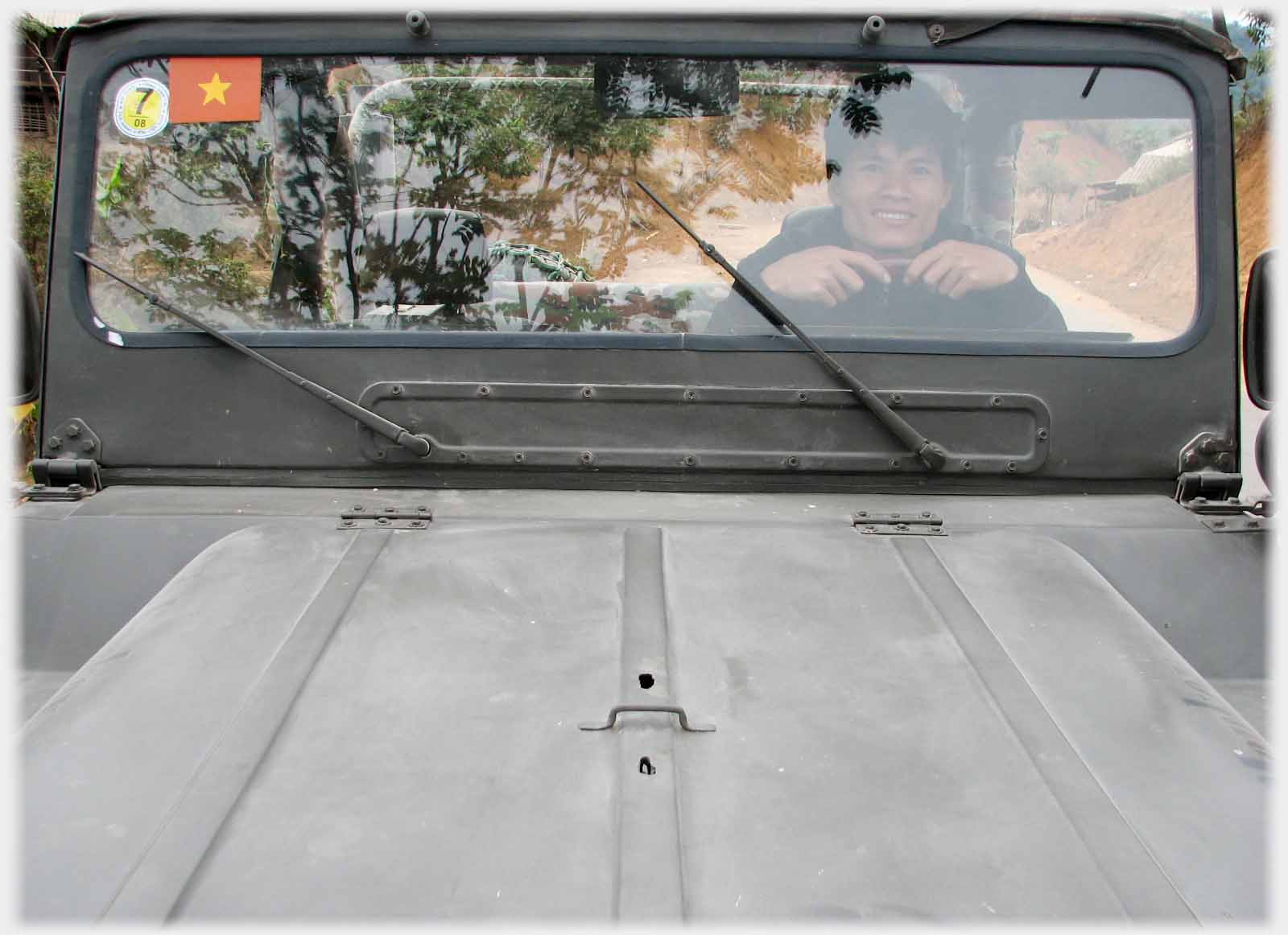 Bonnet and windscreen of Jeep, glass almost opaque with reflections.