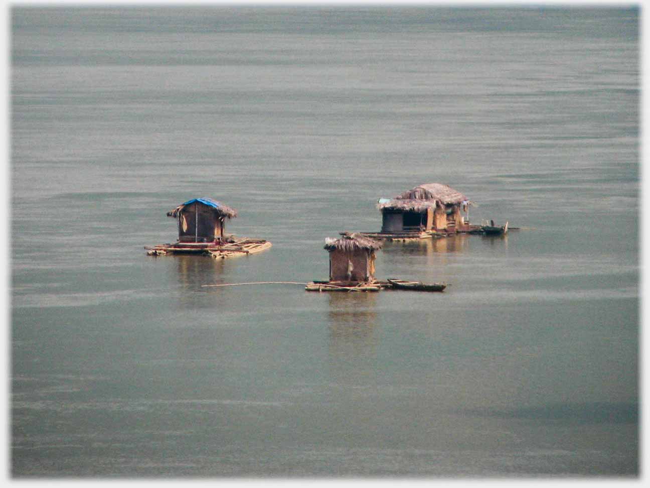 Three small huts on rafts.