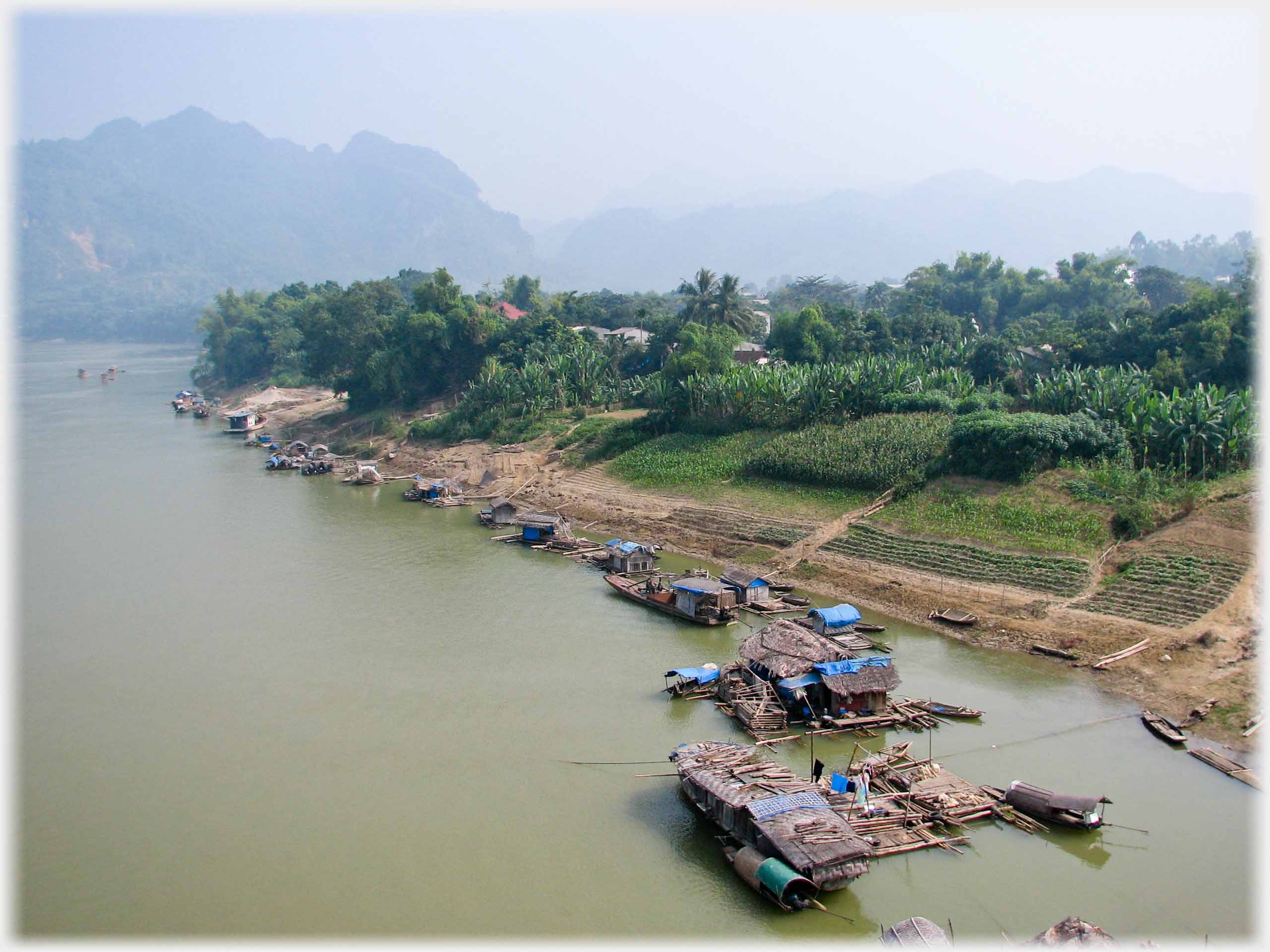 Boats moored along river bank.