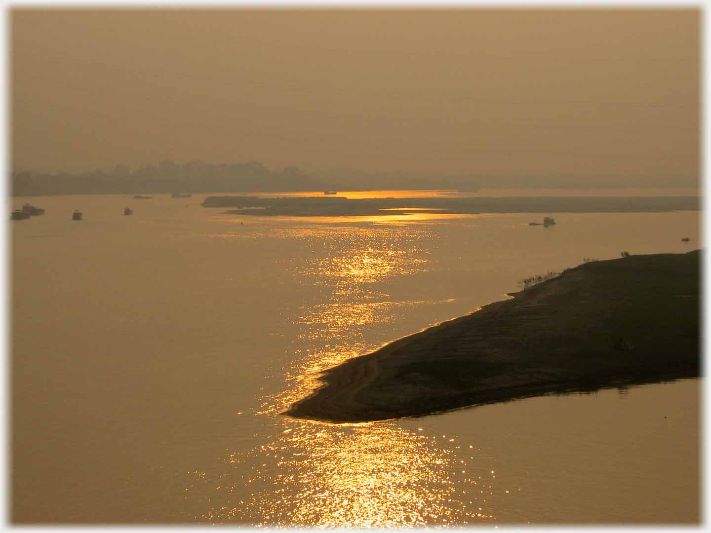 Diminished sun reflection across water with peninsulas breaking reflection.