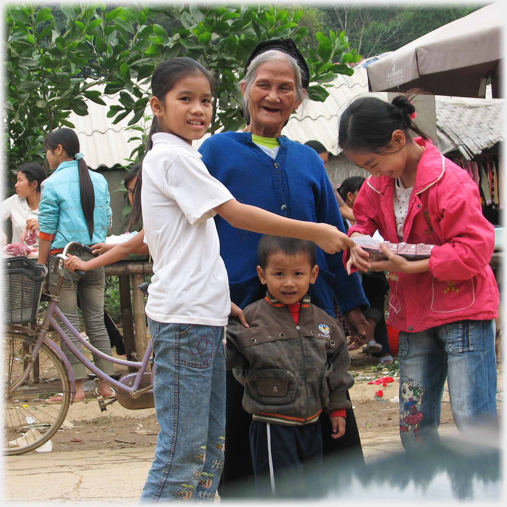 Older woman, two adolescent girls and the youngster noticing the camera.